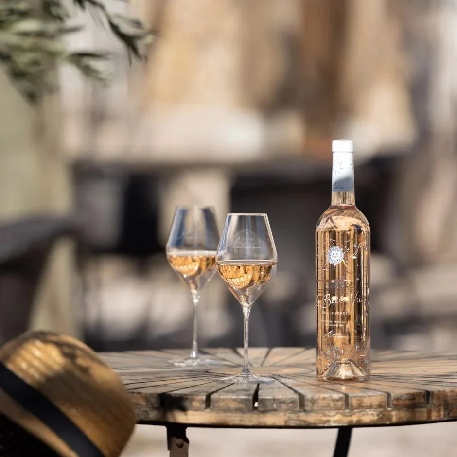 Garrafa La Belle Vie do Château d'Astros com desenho de Arnold d'Alger e duas taças de rosé